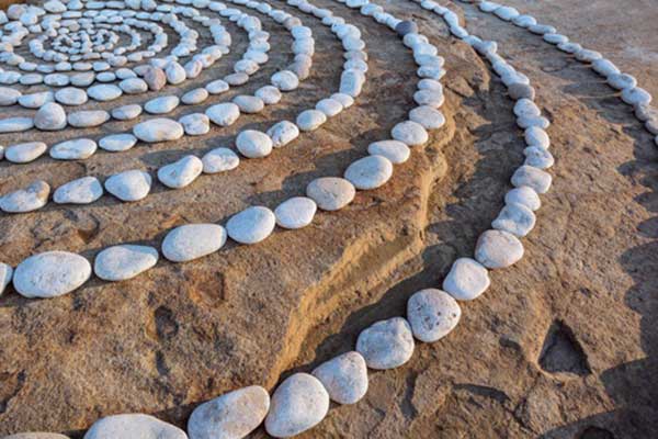 Konzentrische Kreise aus Steinen im Sand